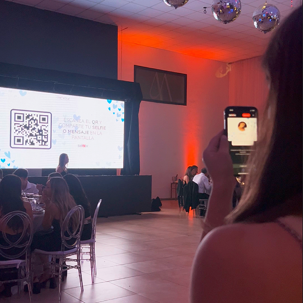 Persona escaneando un QR en la pantalla de unsalón